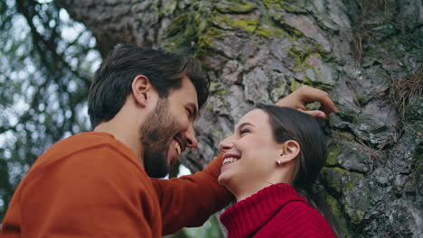 Laughing-couple-standing-forest-tree-spending-happy-holiday-vertical-closeup