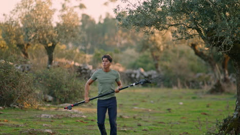 Sweaty-farmer-walking-garden-nature-closeup.-Man-holding-rake-harvest-olives