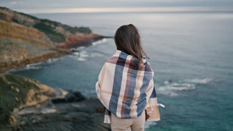 Back-view-relaxed-woman-in-front-gray-ocean.-Girl-looking-on-seascape-vertical