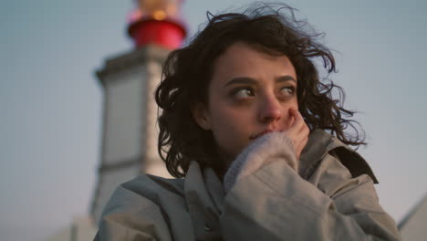 Closeup-woman-posing-seaside-lighthouse.-Lonely-pensive-girl-looking-camera