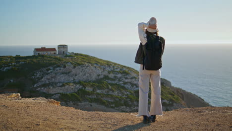 Mountain-traveler-talking-phone-at-quiet-ocean-view.-Hiking-girl-walking-cliff