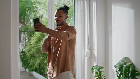 Young-man-talking-phone-at-light-interior-closeup.-Guy-smartphone-video-call
