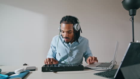 Headphones-man-using-controller-apartment-closeup.-Music-producer-working-home