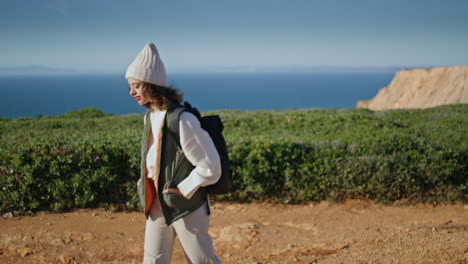 Relaxed-girl-admiring-landscape-at-ocean-cliff.-Young-tourist-walking-pathway