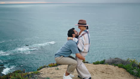Cheerful-couple-dancing-ocean-view-vertically.-Man-lifting-woman-on-sea-shore.