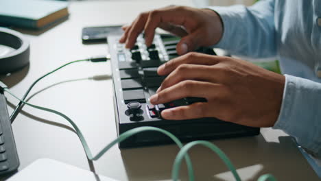Man-hands-using-console-keyboard-closeup.-Unknown-dj-pushing-buttons-mixing-song