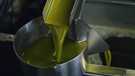 Olive-oil-production-process-at-manufactory-vertical-close-up.-Liquid-flowing