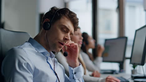 Serious-agent-talking-headset-in-customer-support-office-closeup.-Tired-man-work