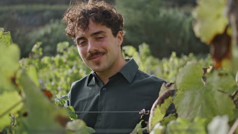 Portrait-grape-plantation-worker-standing-at-vineyard-alone.-Happy-winegrower.