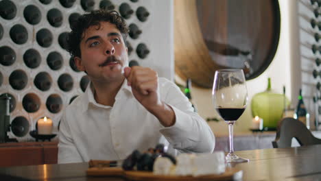 Relaxed-guy-enjoying-wine-with-appetizers-sitting-restaurant-vertical-closeup