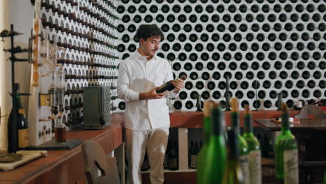 Man-taking-wine-bottle-winery-collection-vertically.-Sommelier-choosing-beverage