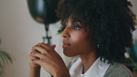 Portrait-pensive-african-woman-with-curly-hairstyle-looking-at-distance-indoors.