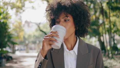 African-woman-drinking-coffee-standing-city-park-closeup.-Girl-enjoying-beverage
