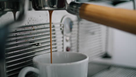 Professional-hot-drink-machine-making-coffee-closeup.-Drink-pouring-in-white-cup