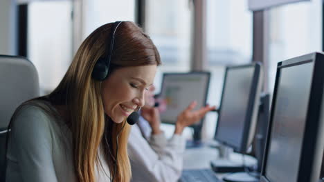 Smiling-service-operator-work-computer-closeup.-Friendly-woman-talking-headset