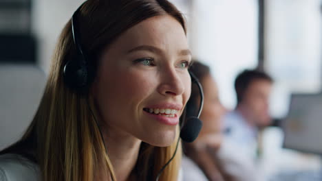 Joyful-agent-speaking-headset-closeup.-Smiling-woman-professional-talking-client