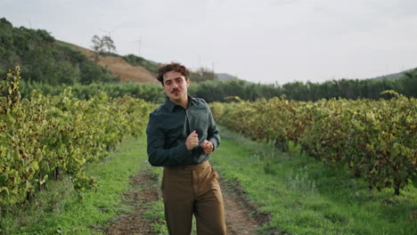 Man-inspecting-grape-plantation-walking-road-between-grapevine-rows.-Vineyard