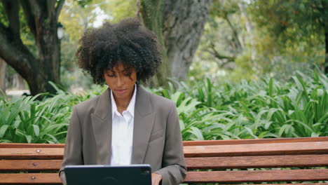 Woman-working-laptop-sitting-on-bench-close-up.-Girl-doing-remote-job-outdoors.