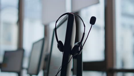 Closeup-hand-taking-headset-at-call-center.-Technical-support-equipment-hanging