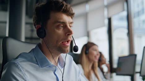 Closeup-technical-assistant-talking-in-call-center.-Focused-man-listening-client