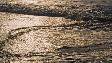 Goldene-Wellen-Umspülen-Morgens-Die-Küste.-Das-Schäumende,-Seichte-Wasser-Des-Ozeans-Reflektiert-Das-Sonnenlicht.
