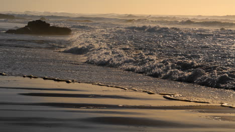 Sea-waves-hitting-beach-in-sunny-morning.-Rocky-coastline-washing-by-foamy-water