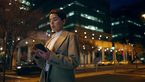 Woman-waiting-night-taxi-in-downtown.-Successful-businesswoman-hold-mobile-phone