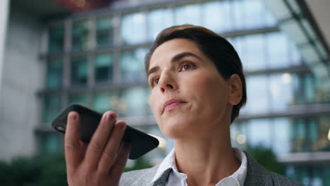 Closeup-businesswoman-recording-message-at-office.-Focused-executive-hold-mobile