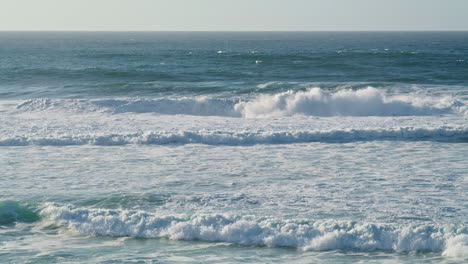 Weiße-Meereswellen-An-Der-Küste-An-Einem-Sonnigen-Morgen.-Stürmisches-Meerwasser,-Das-Schäumt
