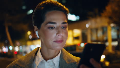 Businesswoman-looking-smartphone-screen-at-night-closeup.-Relaxed-woman-listen