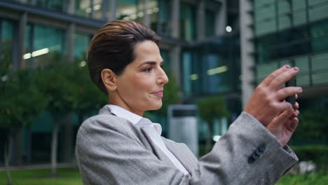 Corporate-woman-recording-mobile-phone-video.-Focused-manager-enjoying-break