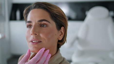 Beautician-checking-skin-health-woman-in-beauty-clinic-closeup.-Facial-examining