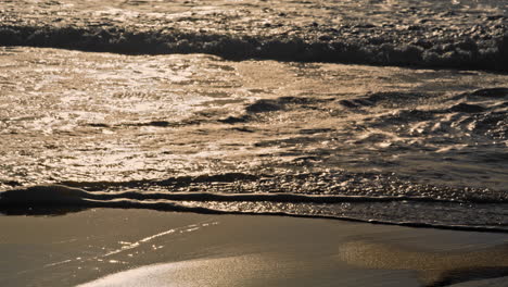 Meereswellen-Waschen-Sandstrand-Bei-Sonnenuntergang.-Goldenes-Sonnenlicht-Reflektiert-Die-Meeresoberfläche