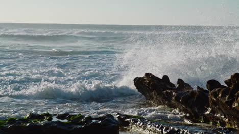 Stürmische-Wellen-Krachen-An-Einem-Sonnigen-Tag-Gegen-Felsen.-Gefährliches-Spritzen-Und-Schäumen-Des-Ozeans