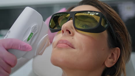 Cosmetician-making-laser-procedure-to-woman-client-in-beauty-salon-close-up.