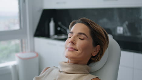 Woman-preparing-cosmetological-procedure-lying-on-chair-beauty-clinic-close-up.