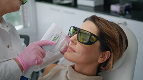 Kosmetikerin-Macht-Gesichtsbehandlung-Mit-Lasergerät-In-Klinik-Nahaufnahme