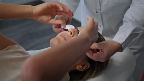 Cosmetologist-putting-protective-glasses-at-woman-face-in-beauty-clinic-closeup.