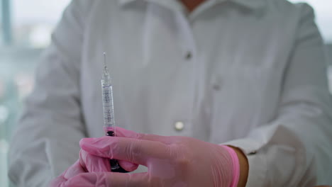 Beautician-holding-syringe-hyaluronic-acid-for-procedure-in-clinic-close-up.