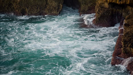 Turquoise-ocean-foaming-cliff-in-summer.-Blue-deep-water-washing-rocky-coastline