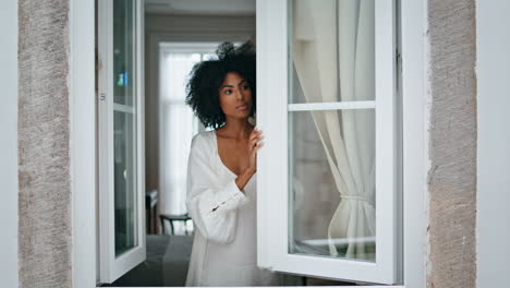Serene-girl-opening-window-morning.-Black-hair-silk-robe-lady-enjoying-weekend
