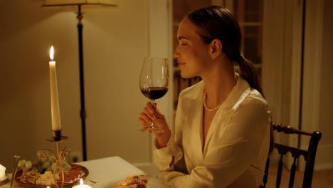 Gorgeous-woman-sniffing-wine-at-candles-table.-Girl-clinking-glasses-husband
