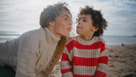 Mom-kid-playing-sand-beach-closeup.-Smiling-parent-having-fun-kissing-cute-son