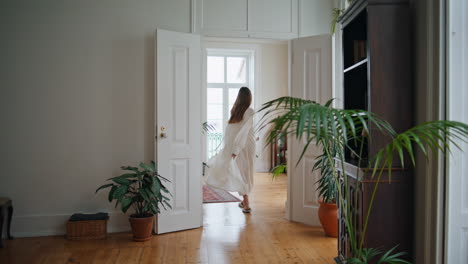 Relaxed-girl-walking-at-cozy-home-back-view.-Happy-woman-spinning-around-alone