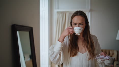 Romantic-model-drinking-cappuccino-morning-closeup.-Relaxed-girl-looking-window