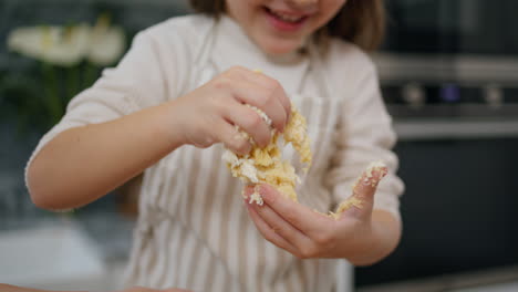 Laughing-kid-making-dough-at-home-portrait.-Smiling-girl-playing-with-pastry