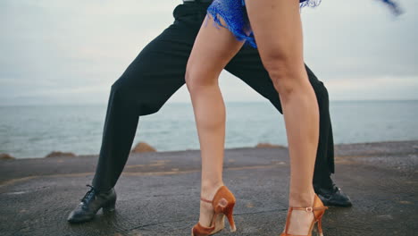 Piernas-De-Bailarines-De-Primer-Plano-Realizando-Sensuales-Pasos-De-Baile-Latino-En-La-Orilla-Del-Mar-Nublado.