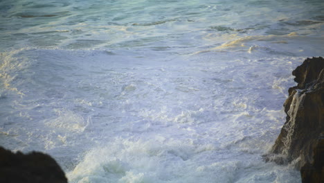 Restless-sea-washing-rocks-at-morning-seaside-closeup.-Ocean-waves-creating-foam
