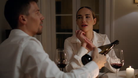 Handsome-boyfriend-pouring-wine-romantic-date.-Couple-having-anniversary-dinner