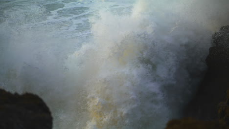 Riesige-Wellen-Treffen-In-Zeitlupe,-Nahaufnahme,-Auf-Felsen-Am-Strand.-Gefährliche-Brandung-Im-Ozean